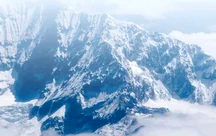 Snow-covered Himalayan peaks rising above the cloud line